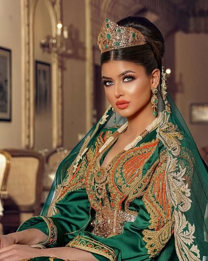 CAFTAN EXPORT Découvrez l'élégance intemporelle du caftan henna, une pièce traditionnelle marocaine magnifiquement ornée. Nos caftans en henna allient beauté et tradition pour des moments inoubliables. Explorez notre collection unique aujourd'hui ! Le caftan Hind, est composé de deux pièces en crêpe de soie blanc, est travaillé avec broderie, sfifa et des boutons en skali bronze. La partie inférieure est un caftan sans manche, confectionnée en drap de soie blanc est également perlé à la main. Il est accompagné d'une ceinture assortie en métal.