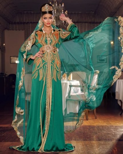 CAFTAN EXPORT Découvrez l'élégance intemporelle du caftan henna, une pièce traditionnelle marocaine magnifiquement ornée. Nos caftans en henna allient beauté et tradition pour des moments inoubliables. Explorez notre collection unique aujourd'hui ! Le caftan Hind, est composé de deux pièces en crêpe de soie blanc, est travaillé avec broderie, sfifa et des boutons en skali bronze. La partie inférieure est un caftan sans manche, confectionnée en drap de soie blanc est également perlé à la main. Il est accompagné d'une ceinture assortie en métal.