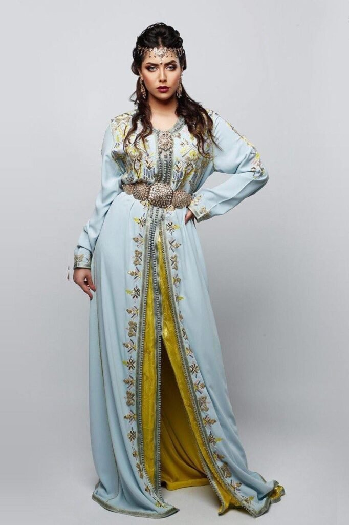 CAFTAN EXPORT Découvrez l'élégance intemporelle du caftan henna, une pièce traditionnelle marocaine magnifiquement ornée. Nos caftans en henna allient beauté et tradition pour des moments inoubliables. Explorez notre collection unique aujourd'hui ! Le caftan Siham, composé de deux pièces en draps de soie vert, travaillé en zewak maalam, sfifa et button en skali doré. Le bas est confectionné en lamé doré pailletée, Il est accompagné d'une ceinture assortie en métal.