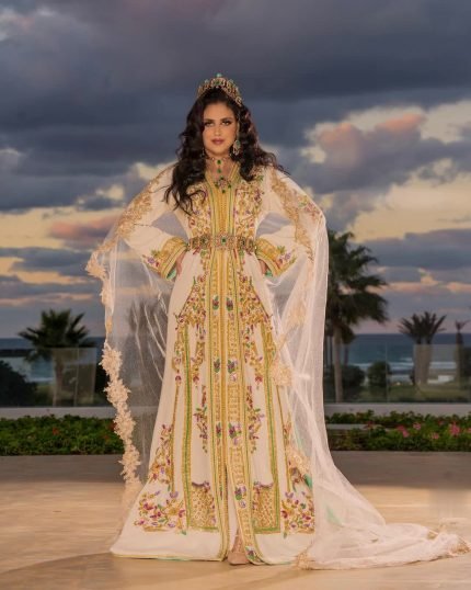 CAFTAN EXPORT Découvrez l'élégance intemporelle du caftan henna, une pièce traditionnelle marocaine magnifiquement ornée. Nos caftans en henna allient beauté et tradition pour des moments inoubliables. Explorez notre collection unique aujourd'hui ! Ce caftan est parfait pour une cérémonie helal. Fabriqué en tissu crêpe de soie, il est brodé et perlé à la main. Le caftan par-dessous, en tissu drap de soie, est accompagné d'une ceinture en métal doré.