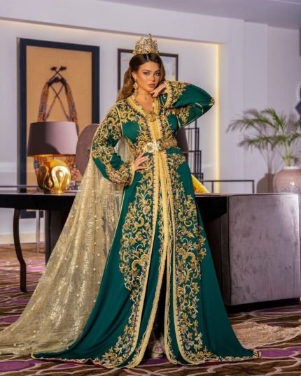 CAFTAN EXPORT Découvrez l'élégance intemporelle du caftan henna, une pièce traditionnelle marocaine magnifiquement ornée. Nos caftans en henna allient beauté et tradition pour des moments inoubliables. Explorez notre collection unique aujourd'hui ! Le caftan, composé de deux pièces en velours de soie vert royal, est travaillé avec broderie, sfifa et des boutons en skali doré. La partie inférieure est un caftan sans manche, confectionnée en drap de soie vert royal est également perlé à la main. Il est accompagné d'une ceinture assortie en métal.