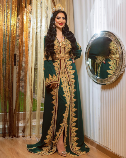 CAFTAN EXPORT Découvrez l'élégance intemporelle du caftan henna, une pièce traditionnelle marocaine magnifiquement ornée. Nos caftans en henna allient beauté et tradition pour des moments inoubliables. Explorez notre collection unique aujourd'hui ! Takchita marocaine haut couture composé de deux pièces. La première pièce est confectionnée en crêpe de soie brodée de fils dorés et rouge, agrémentée de pierres précieuses dorées et rouge de qualité exceptionnelle qui scintillent sous la lumière. La partie inférieure du caftan est réalisée en tissu draps de soie. Elle est accompagnée d'une ceinture en métal doré.