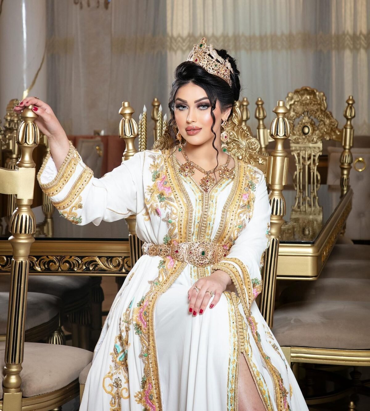 CAFTAN EXPORT Découvrez l'élégance intemporelle du caftan henna, une pièce traditionnelle marocaine magnifiquement ornée. Nos caftans en henna allient beauté et tradition pour des moments inoubliables. Explorez notre collection unique aujourd'hui ! Le Caftan Maroua se compose de deux pièces en crêpe de soie blanc, travaillé en broderies dorées, roses fuchsia et pistache, de sfifa et de boutons en skali bronze, perlés entièrement à la main en cristal. Le bas est confectionné en drap de soie blanc et est accompagné d'une ceinture assortie.