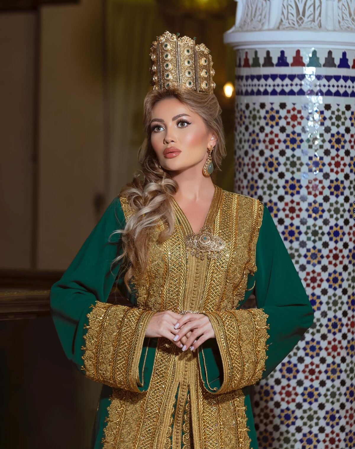 Caftan Market Place Découvrez l'élégance intemporelle du caftan henna, une pièce traditionnelle marocaine magnifiquement ornée. Nos caftans en henna allient beauté et tradition pour des moments inoubliables. Explorez notre collection unique aujourd'hui ! Le caftan Chahinaz est composé de deux pièces en crêpe de soie vert, ornées de broderies dorées, de sfifa et de boutons en skali doré. La partie inférieure est un caftan confectionné en drap de soie vert et perlé à la main. Il est accompagné d'une ceinture assortie en métal.