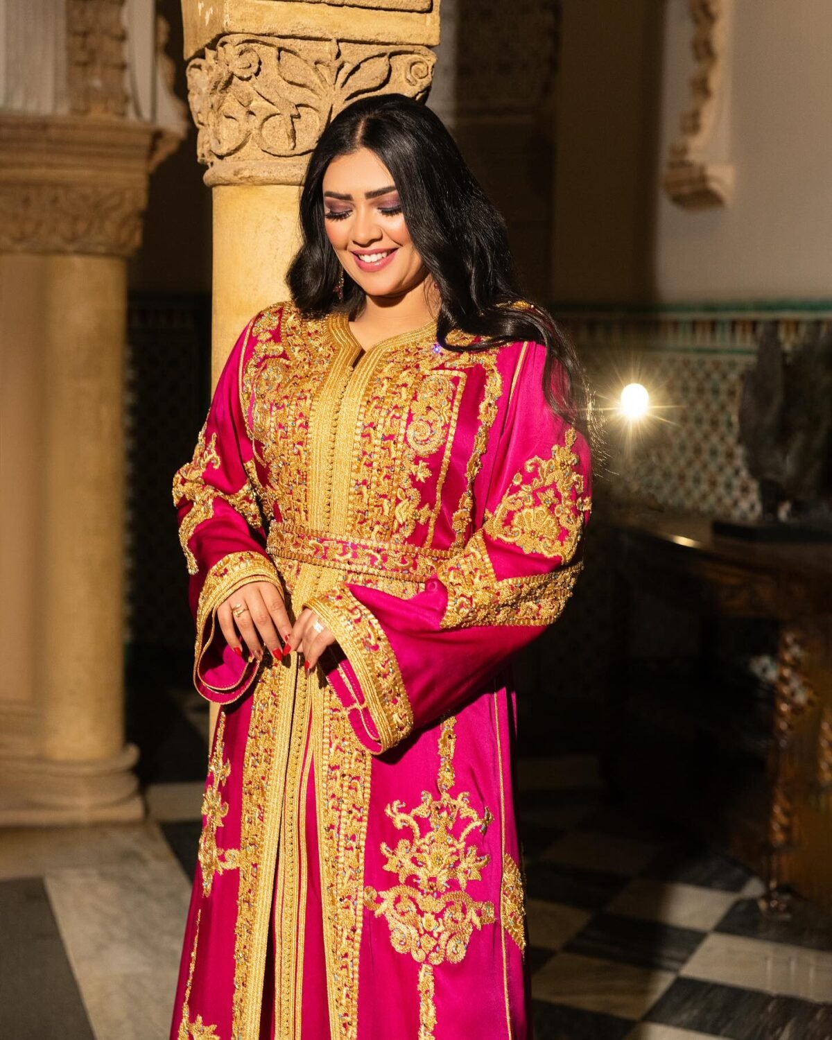 Caftan Market Place Découvrez l'élégance intemporelle du caftan henna, une pièce traditionnelle marocaine magnifiquement ornée. Nos caftans en henna allient beauté et tradition pour des moments inoubliables. Explorez notre collection unique aujourd'hui ! Le caftan Nariman se compose de deux pièces en satin duchesse rose, ornées de broderies dorées, de perles en cristal, de sfifa et de boutons en skali doré. La partie inférieure est confectionnée en drap de soie rose, perlé à la main. Il est accompagné d'une ceinture assortie en métal.