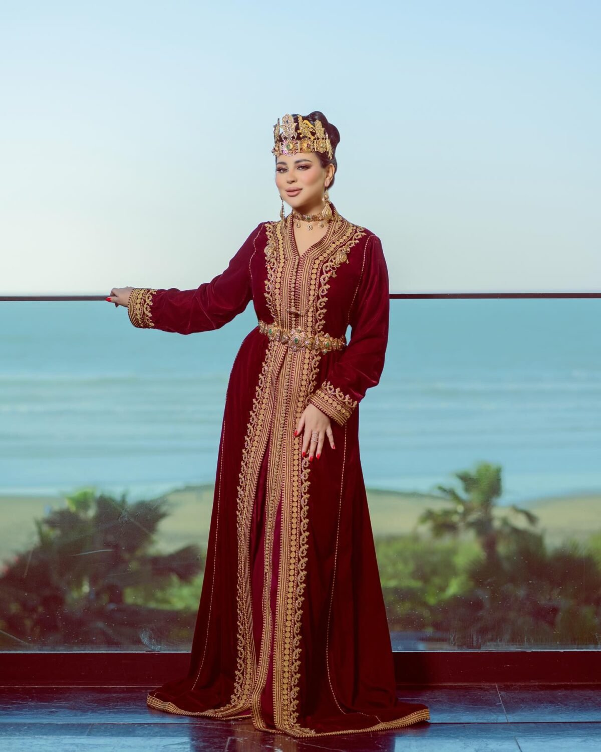 Caftan Market Place Découvrez l'élégance intemporelle du caftan henna, une pièce traditionnelle marocaine magnifiquement ornée. Nos caftans en henna allient beauté et tradition pour des moments inoubliables. Explorez notre collection unique aujourd'hui ! Le caftan Narjiss se compose de deux pièces en velours Bordeau, ornées de broderies dorées, de perles en cristal, de sfifa et de boutons en skali doré. La partie inférieure est confectionnée en drap de soie Bordeau, perlé à la main. Il est accompagné d'une ceinture assortie en métal.