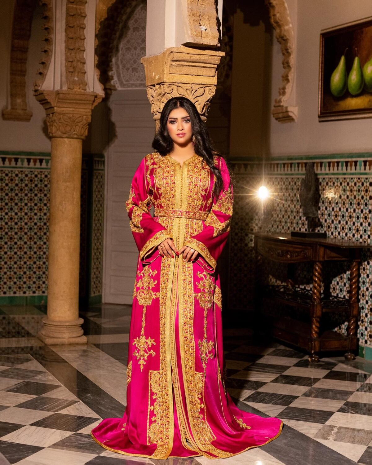 Caftan Market Place Découvrez l'élégance intemporelle du caftan henna, une pièce traditionnelle marocaine magnifiquement ornée. Nos caftans en henna allient beauté et tradition pour des moments inoubliables. Explorez notre collection unique aujourd'hui ! Le caftan Nariman se compose de deux pièces en satin duchesse rose, ornées de broderies dorées, de perles en cristal, de sfifa et de boutons en skali doré. La partie inférieure est confectionnée en drap de soie rose, perlé à la main. Il est accompagné d'une ceinture assortie en métal.