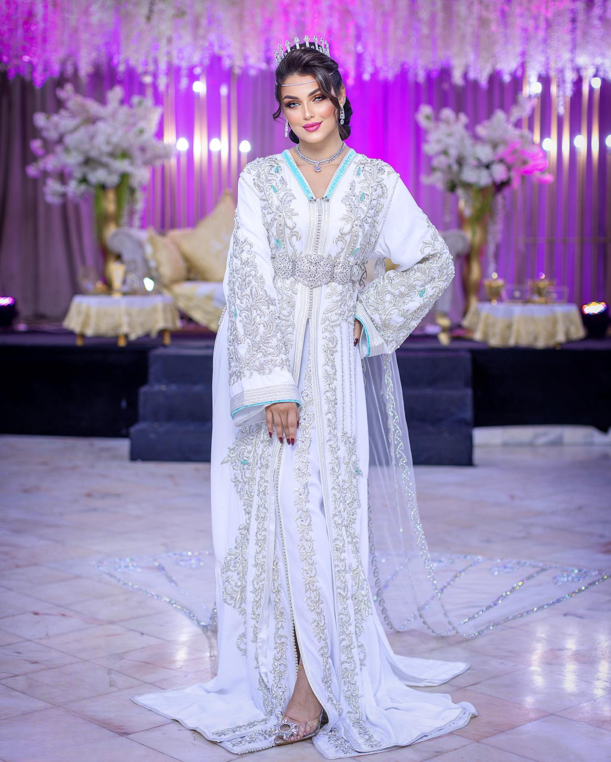 CAFTAN EXPORT Découvrez l'élégance intemporelle du caftan henna, une pièce traditionnelle marocaine magnifiquement ornée. Nos caftans en henna allient beauté et tradition pour des moments inoubliables. Explorez notre collection unique aujourd'hui ! Caftan de mariage en crêpe de soie blanc, brodé en fil argent et perlé à la main. Le bas en drap de soie est également brodé et perlé à la main, livré avec une ceinture assortie en métal argenté.