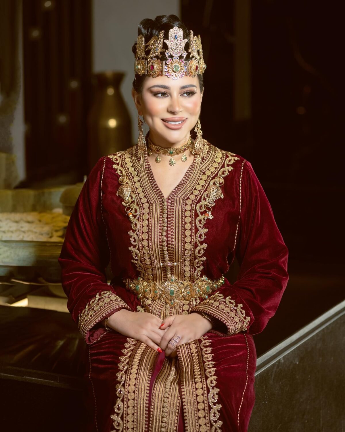 Caftan Market Place Découvrez l'élégance intemporelle du caftan henna, une pièce traditionnelle marocaine magnifiquement ornée. Nos caftans en henna allient beauté et tradition pour des moments inoubliables. Explorez notre collection unique aujourd'hui ! Le caftan Narjiss se compose de deux pièces en velours Bordeau, ornées de broderies dorées, de perles en cristal, de sfifa et de boutons en skali doré. La partie inférieure est confectionnée en drap de soie Bordeau, perlé à la main. Il est accompagné d'une ceinture assortie en métal.